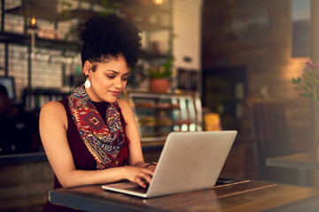 Poster - Making some final edits to her latest blog post. Cropped shot of an attractive young woman working on her laptop in a cafe.