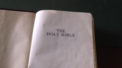 Wall Mural - Opening up the Holy Bible with leather cover. Turning the cover to title page.