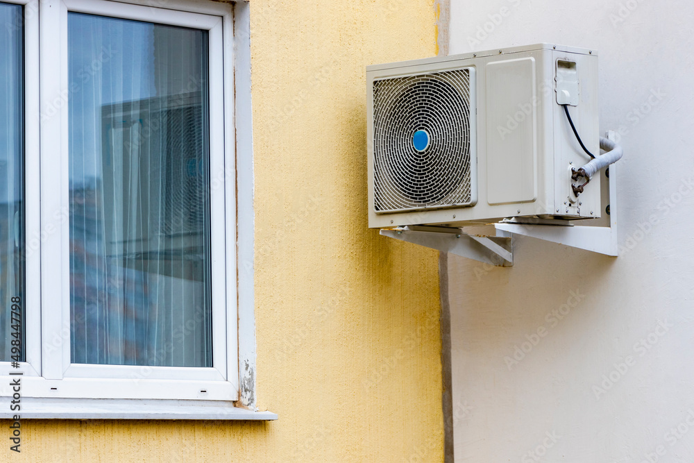 An air conditioning system installed outside on the wall of a ...