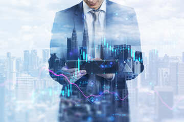 Aufkleber - Attractive young european businessman using tablet standing on abstract blue city background with index, candlestick forex chart and mock up place. 