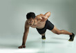 © T Hinrichsen/peopleimages.com - Youve got to push it. Studio shot of a young man doing a one hand pushup against a gray background.