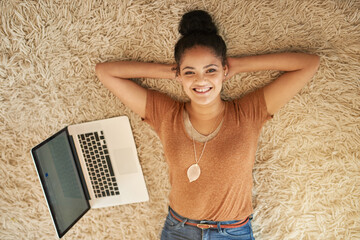 Poster - Some relaxation before I go back to online shopping. Shot of a beautiful young woman lying down next to a laptop at home.