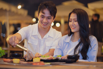 Wall Mural - Image of young Asian couple eating dinner together