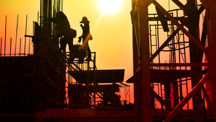 construction worker workloads in construction site with  abstract sky sunset background