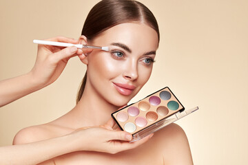 Wall Mural - makeup artist applies eye shadow. beautiful woman face. perfect makeup. make-up detail. beauty girl 