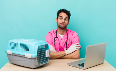 Wall Mural - hispanic handsome man shrugging, feeling confused and uncertain. veterinarian concept