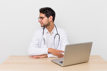 Wall Mural - hispanic handsome man on profile view thinking, imagining or daydreaming. physician concept