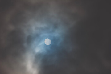 Wall Mural - Solar Eclipse. Partial phase on a cloudy day.