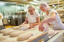 Baker Apprentice With Boss Baking Bread Under Guidance