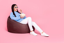 Portrait Of Attractive Cheerful Girl Sitting Eating Pop Corn Enjoying Tv Show Isolated Over Pink Pastel Color Background