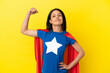 © luismolinero - Woman isolated on yellow background in superhero costume and doing strong gesture