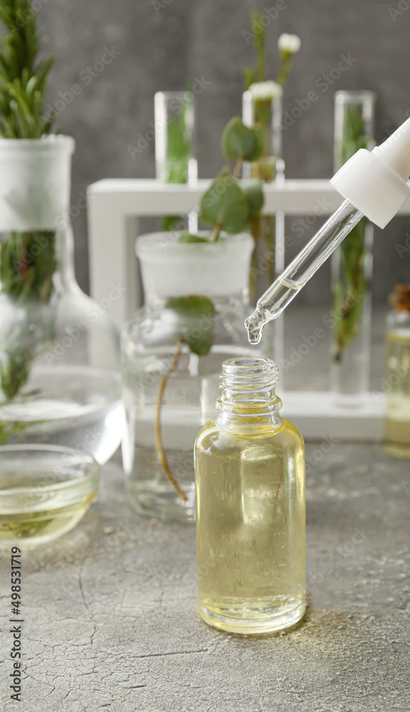 Bottle of natural essential oil on grunge background