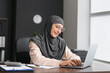 © Pixel-Shot - Muslim secretary working on laptop in office