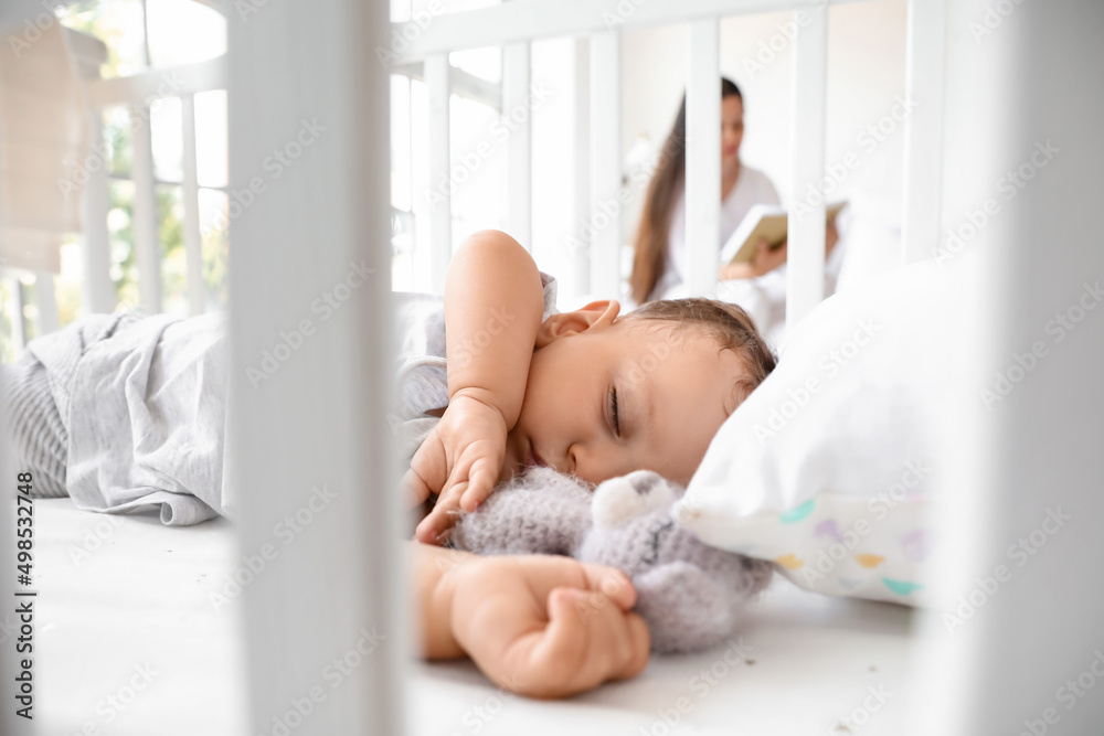 Adorable baby with toy sleeping in crib, closeup