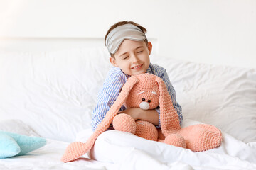 Wall Mural - Little boy with sleep mask and toy in bed