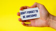 © Sviatlana - Don't forget to be cool business card in a male hand on a yellow background. Motivation for action