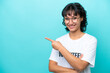 Young volunteer Argentinian woman isolated on blue background pointing finger to the side