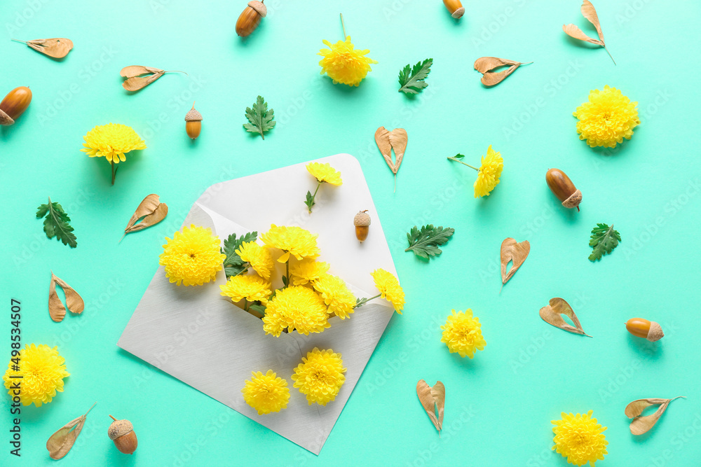 Envelope with yellow chrysanthemum flowers and natural forest decor on color background