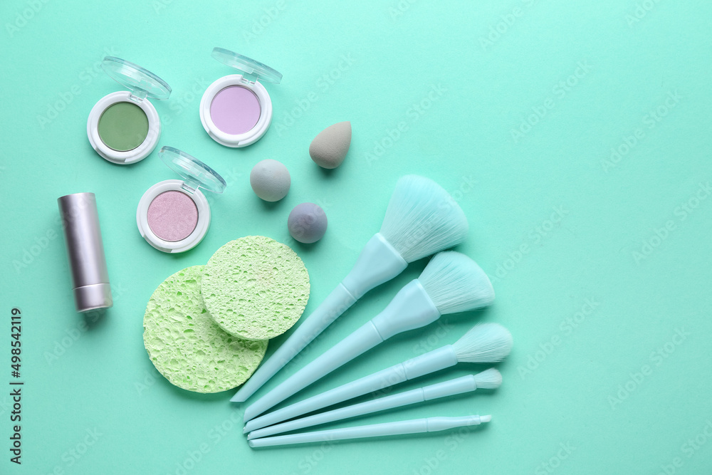 Composition with cosmetic products on turquoise background, top view