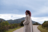 Fototapeta Konie - Portrait of woman in coat with mountain in background