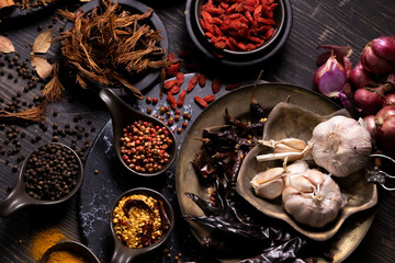 Various type of oriental earthy flavor dry spices on dark wooden table such as turmeric, black pepper, chili flake, bay leaf, for medicinal and herbal use in healing and cooking usage