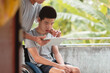 © GAYSORN - Young man with a disability and parent help to using mobile phone for selfie or video chat or social media, He had a tremor caused by Cerebral palsy, or CP has symptoms similar to Parkinson's disease.