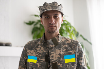 Wall Mural - Ukrainian man warrior dressed in a military pixel uniform the yellow-blue flag of Ukraine