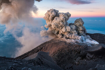 Poster - Scenic view of smoke going out of a rocky volcanic mountain during sunset