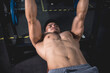 A fit asian man squeezing his pecs to get the extra pump while doing dumbbell bench presses. Working out chest muscles.