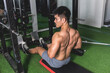 A shirtless asian man performing seated V-bar cable rows at the gym. Holding the rep for extra squeeze.Rowing machine exercise to train and develop back muscularity and mass.