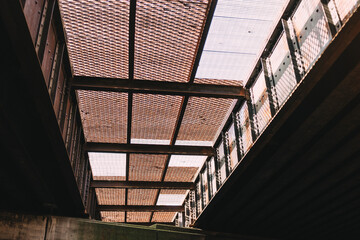 Low angle shot of a metal grate back lit underneath a highway overpass