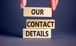 © Dzmitry - Our contact details symbol. Concept words Our contact details on wooden blocks. Businessman hand. Beautiful grey table grey background. Business our contact details concept. Copy space.