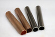 Closeup shot of copper and titanium alloy tubes isolated on a white background