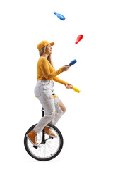 Canvas Print - Young female riding a unicycle and juggling