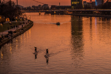 Breathtaking view of the cityscape with high modern buildings reflecting on the water during sunset