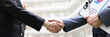 Business man and woman with documents shaking hands closeup