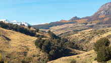 Photo Of Mountain Grassland And Shrubland Showing A Snowy Mountain Top On A Sunny Day