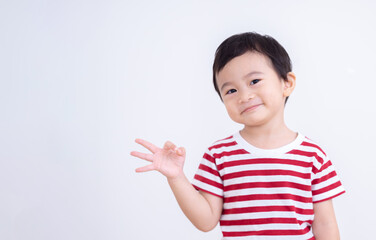 Asian little boy showing ok sign with fingers on white background, advertisement and people concept.