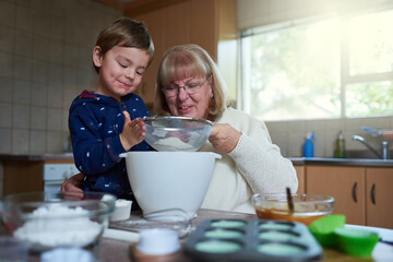 Sticker - Baking fun with gran. Cropped shot of a woman baking with her grandson at home.