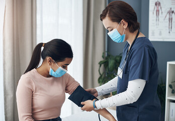 Poster - Im just going to put this around your arm. Shot of a young female doctor checking a patients blood pressure in an office.