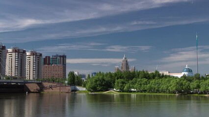 Wall Mural - Bridge over Ishim with park timelapse with the transport and clouds on the background. Central Asia, Kazakhstan, Astana