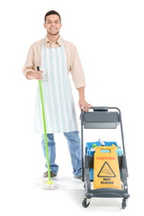 Poster - Young male worker of cleaning service with supplies in trolley on white background