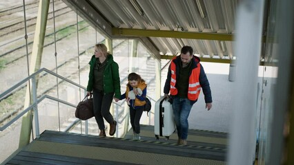 Wall Mural - Volunteer helping Ukrainian mother with child, refugees, at train station.