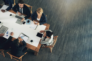 Aufkleber - The business team to beat. High angle shot of a team of businesspeople working around a table in the office.