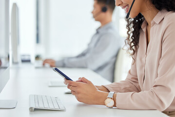 Poster - Logging inquiries through multiple digital portals. Closeup shot of a call centre agent using a cellphone while working in an office with her colleague in the background.
