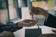 © ArLawKa - Sales representatives offer home purchase contracts to purchase a house or apartment and give home key chains to customers in the office buying or selling and renting real estate ideas.