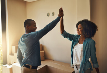 Poster - We got this babe. Shot of a cheerful young couple giving each other a high five inside at home during the day.
