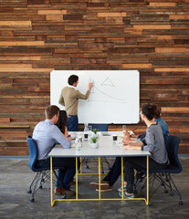 Poster - This is where we have to focus on. Shot of a group of coworkers sitting at a conference table during a presentation.