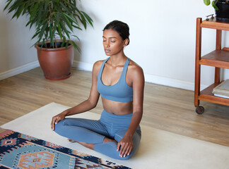 Wall Mural - If it disturbs your peace, let it go. Shot of a beautiful young woman practising yoga at home.