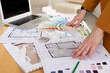© tgordievskaya - Woman architect working on interior renovation in workplace. Designer choosing color samples according to the visualization and blueprints of the project. Architecture and interior design concept.
